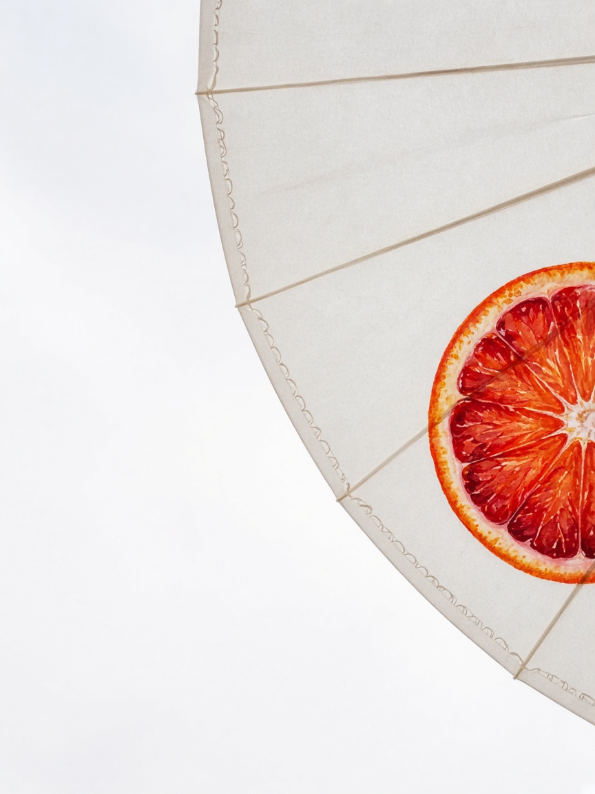 The underside of shade — PortraitLuxe Underside of a white paper parasol painted with a blood-orange slice, sky at the cut edge